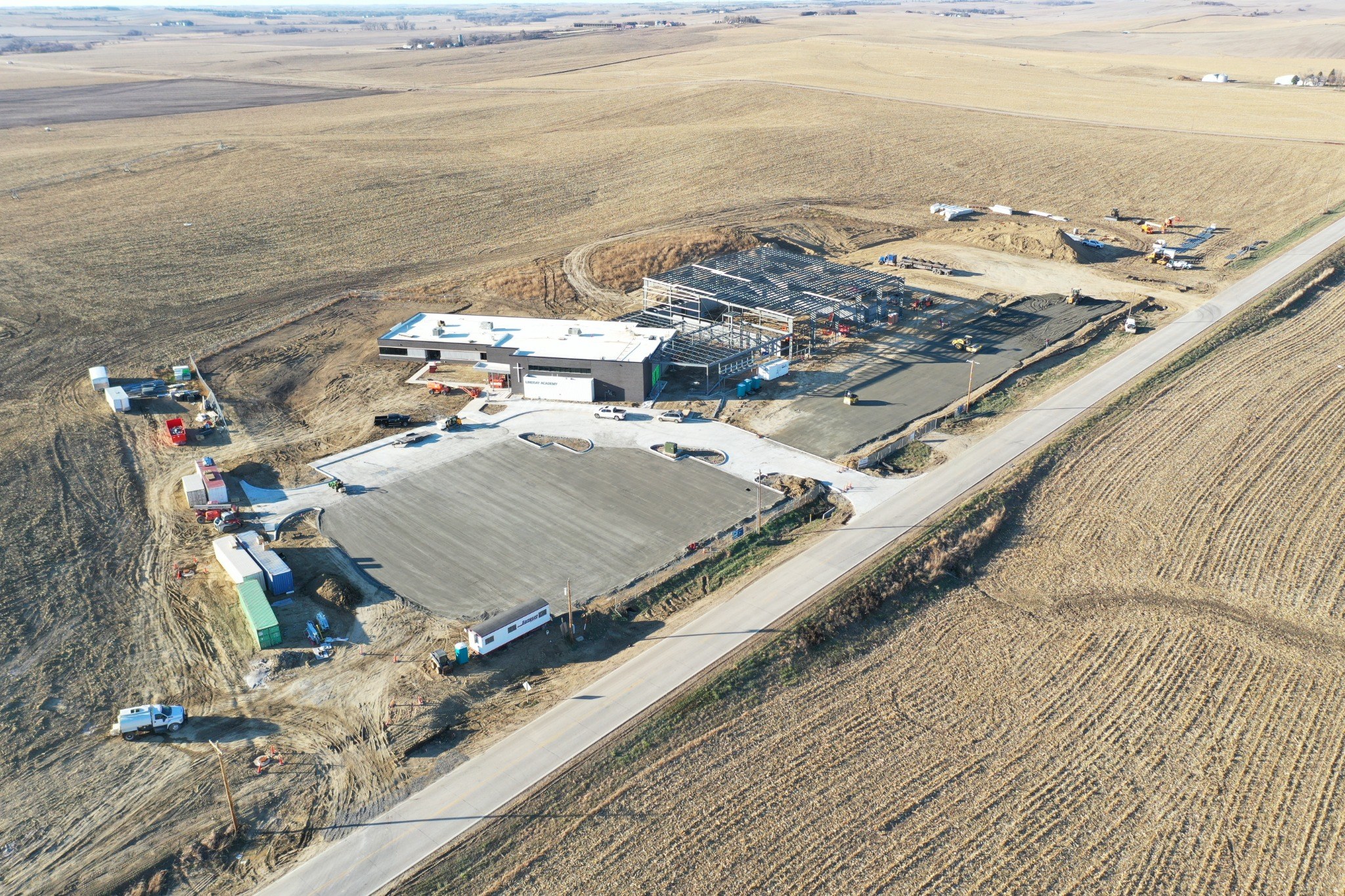 Aerial view of a large concrete commercial site beside farm fields.