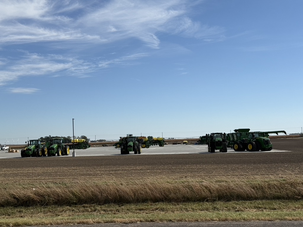 Agricultural equipment on a large paved equipment yard