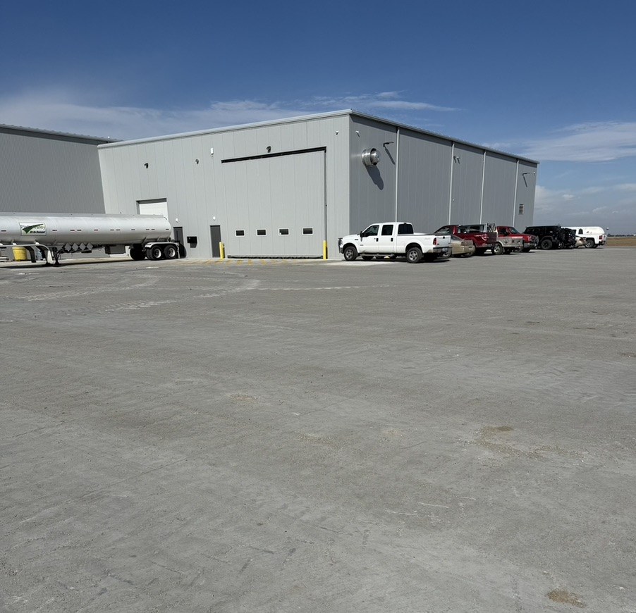 Concrete industrial yard outside a large warehouse.